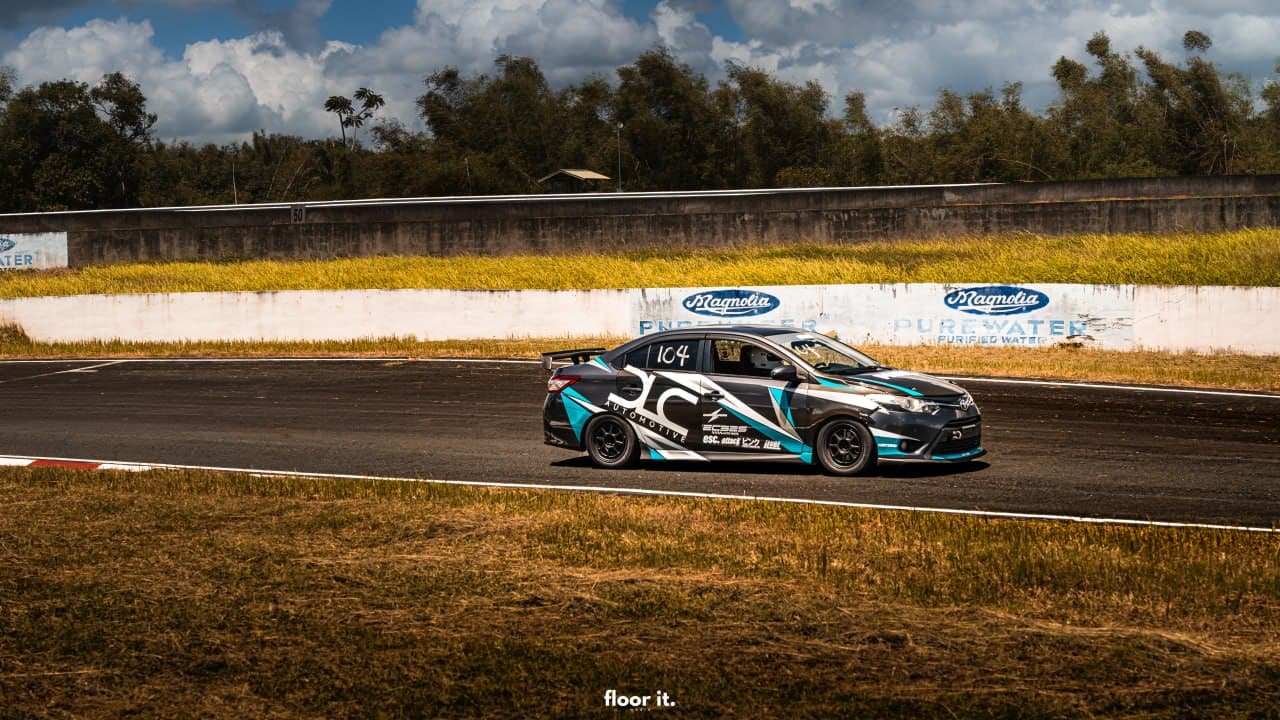 DLC Vios race car in black, white, and cyan-teal livery