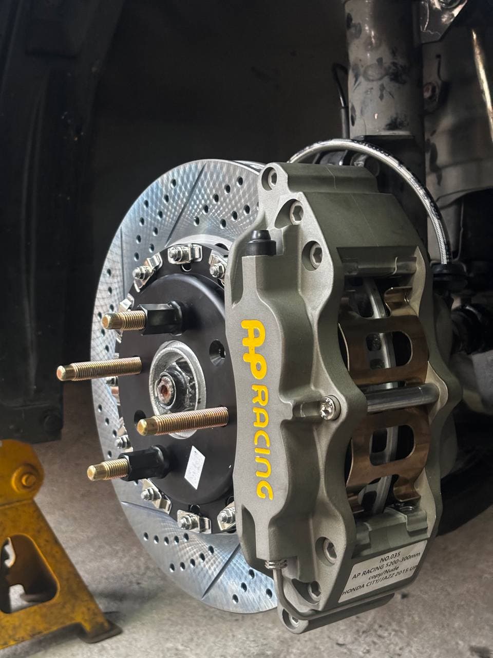 Extended wheel studs installed with an AP Racing brake caliper and drilled brake rotor